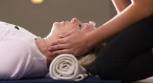 Kvinde, der ligger ned og modtager massage eller healing